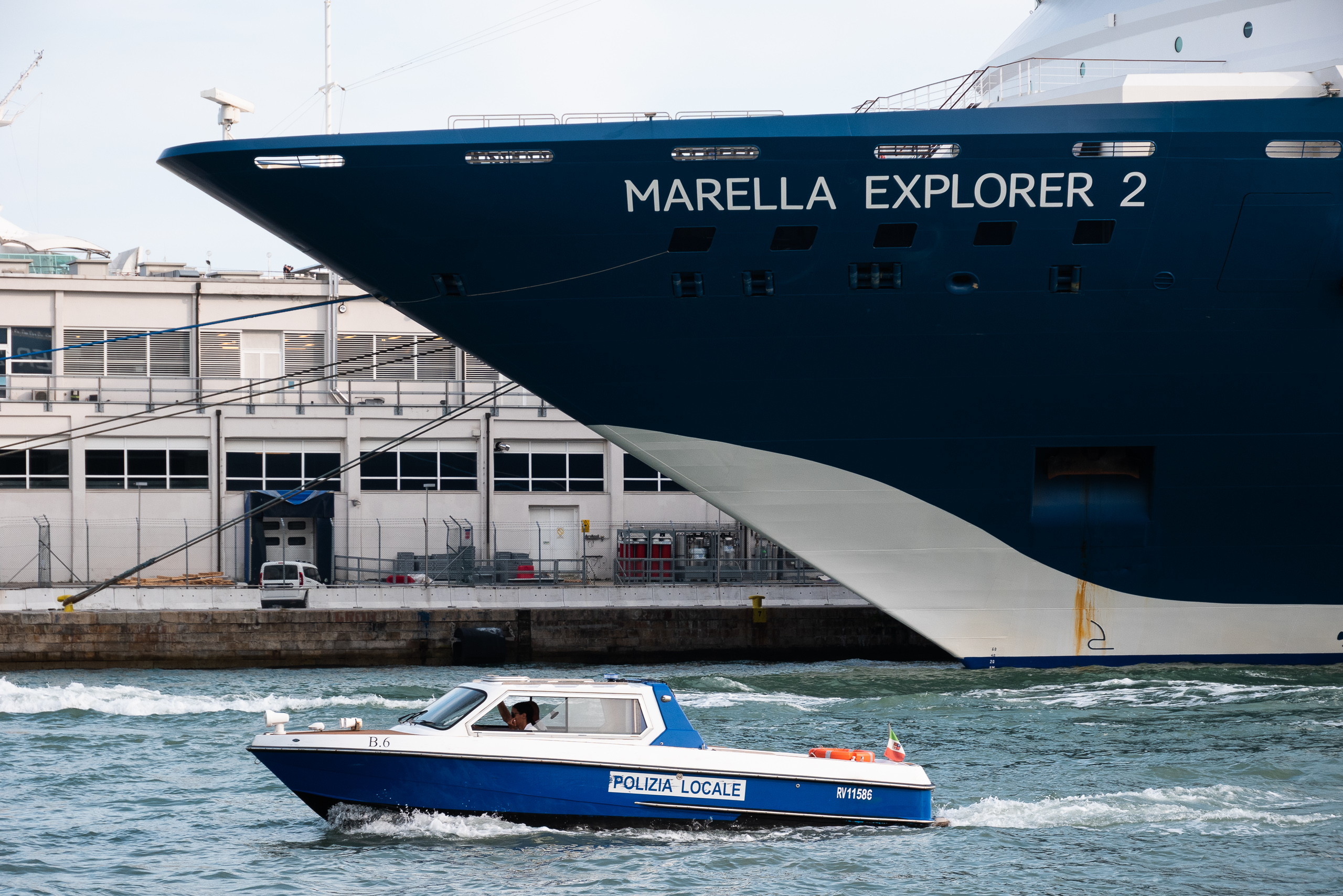Der Bug der „Marella Explorer 2“ überragt das Polizeiboot